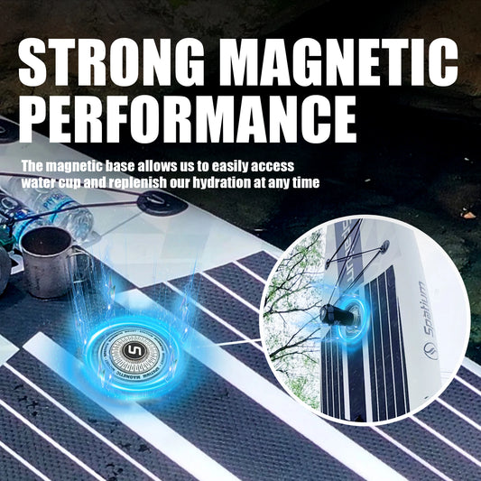 A round magnetic base attaches securely to the Spatium Premium Paddle Board, holding a water cup. Text highlights Strong Magnetic Performance for convenient access and hydration, with the paddleboard deck and outdoor scenery in view.